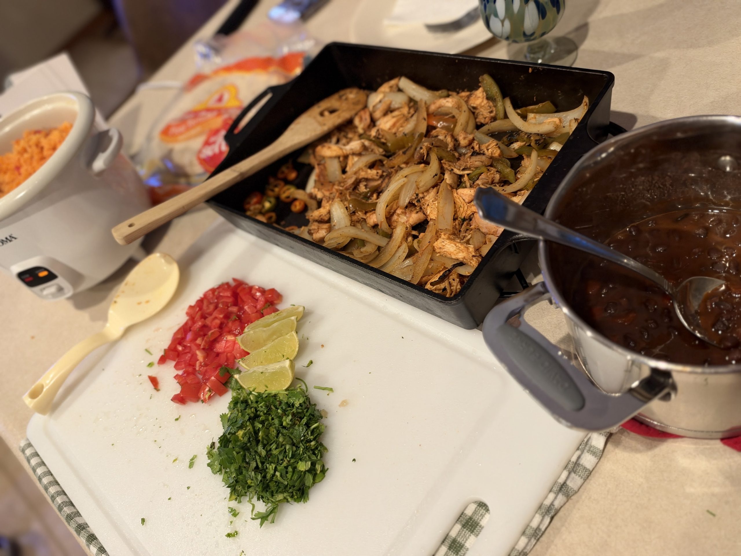 Chicken fajitas, Spanish rice, black beans, chopped tomato, cilantro and lime ready to serve