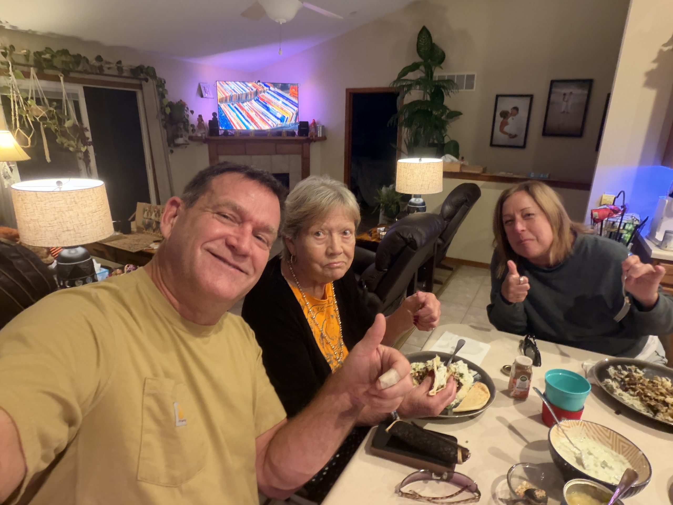 Kirk, his mother Jerre and Kim smiling and giving thumbs-up around the table after beef curry dinner
