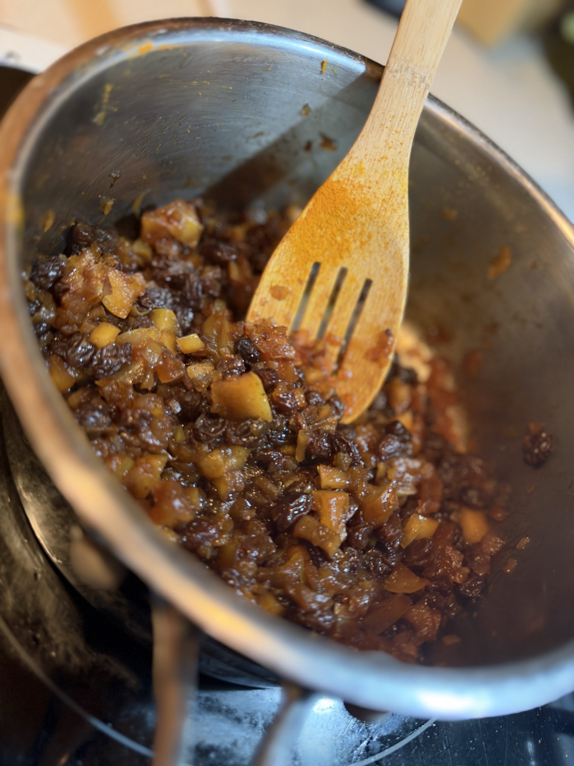 Diced apples, raisins and onion cooking together in a saucepan