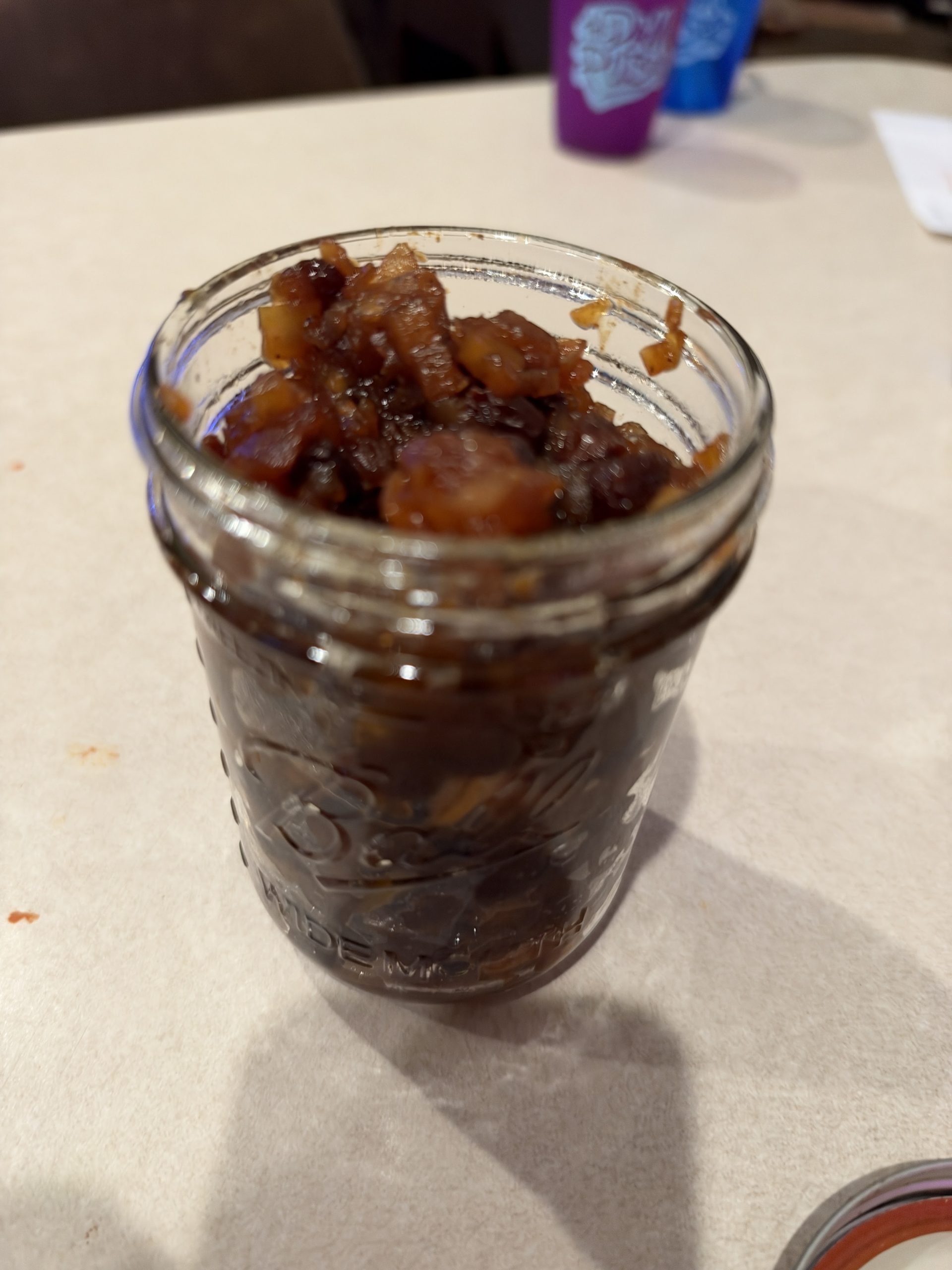 Finished chunky homemade apple-raisin chutney packed into a glass jar